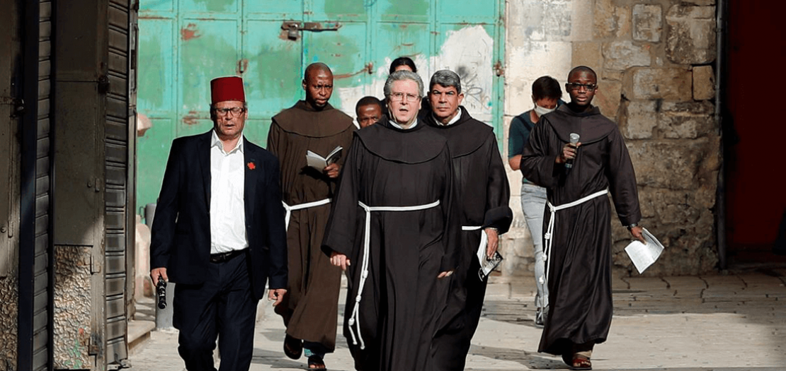 الأب فرانشيسكو باتون ورهبان آخرون يسيرون في أحد شوارع القدس (رويترز)