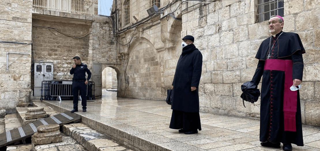 المدبر الرسولي للبطريركية اللاتينية في القدس رئيس الأساقفة بييرباتيستا بيتسابالا، يقف عند مدخل كنيسة القيامة في القدس، يوم الجمعة العظيمة