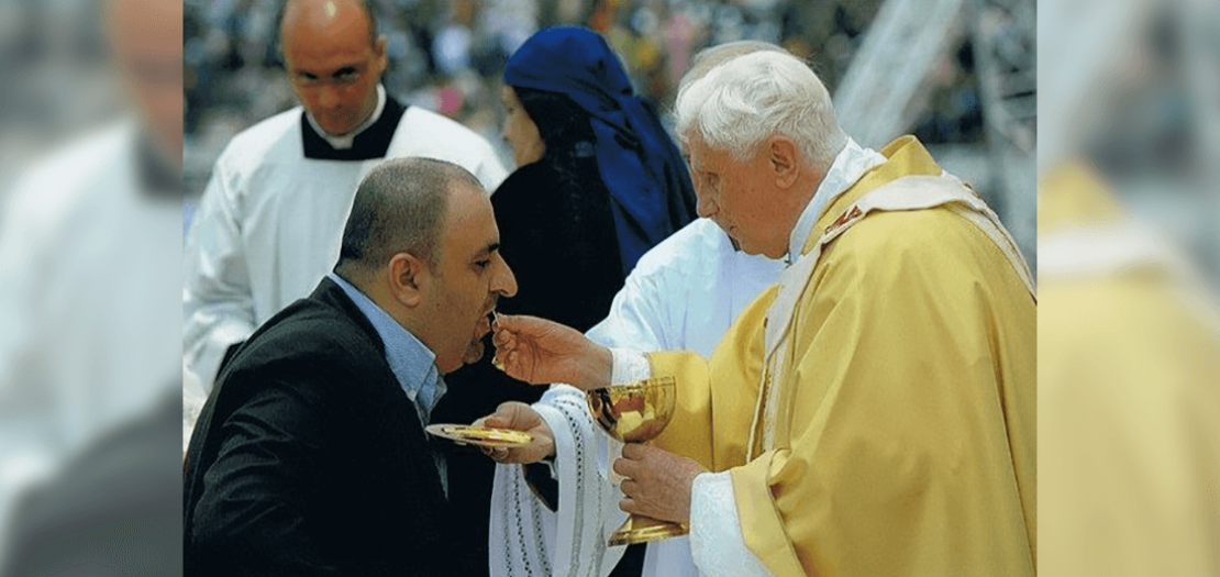 كاتب المقال يتقرّب من المناولة المقدسة على يد قداسة البابا بندكتس السادس عشر في القداس التاريخي في ستاد عمان بالأردن، أيار 2009