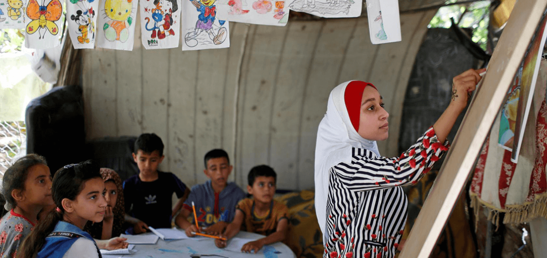 الطالبة الفلسطينية فجر حميد (13 عامًا) تدرس لجيرانها اللغة العربية في قطاع عزة نظرا لغلق المدارس جراء فيروس كورونا