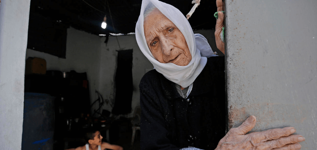 فلسطينية لاجئة عاشت نكبة 1948 عند مدخل منزلها في مخيم الشاطئ للاجئين في مدينة غزة في 15 أيار 2020، حيث احيا الفلسطينيون الذكرى 72 لنكبة داخل منازلهم بسبب جائحة كورونا