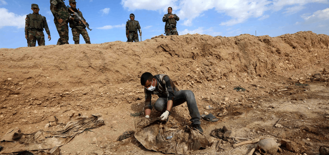 عراقي يبحث عن رفات أيزيديين قتلهم تنظيم داعش بسنجار شمال غرب العراق، في 3 شباط 2015