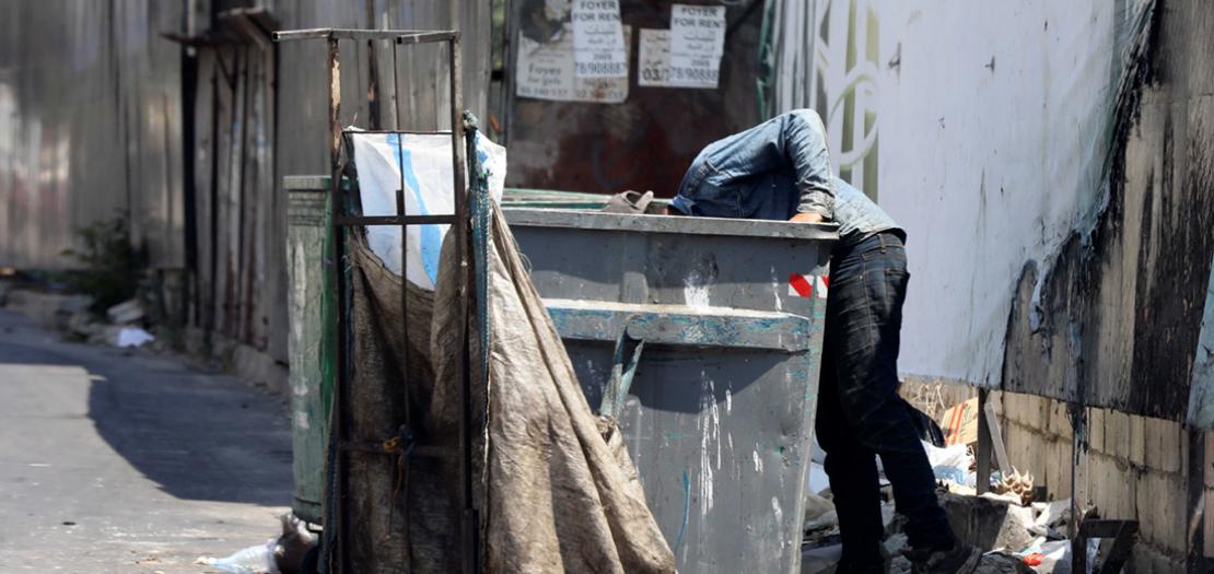 رجل يبحث عن طعام في أحد مستوعبات النفايات في بيروت