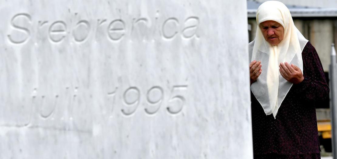 ميريا دجوغاز (71 عاما) من مسلمي البوسنة تصلي عند قبري نجليها اللذين قتلا في مجزرة سريبرينيتسا، في النصب التذكاري قرب المدية، 3 تموز 2020