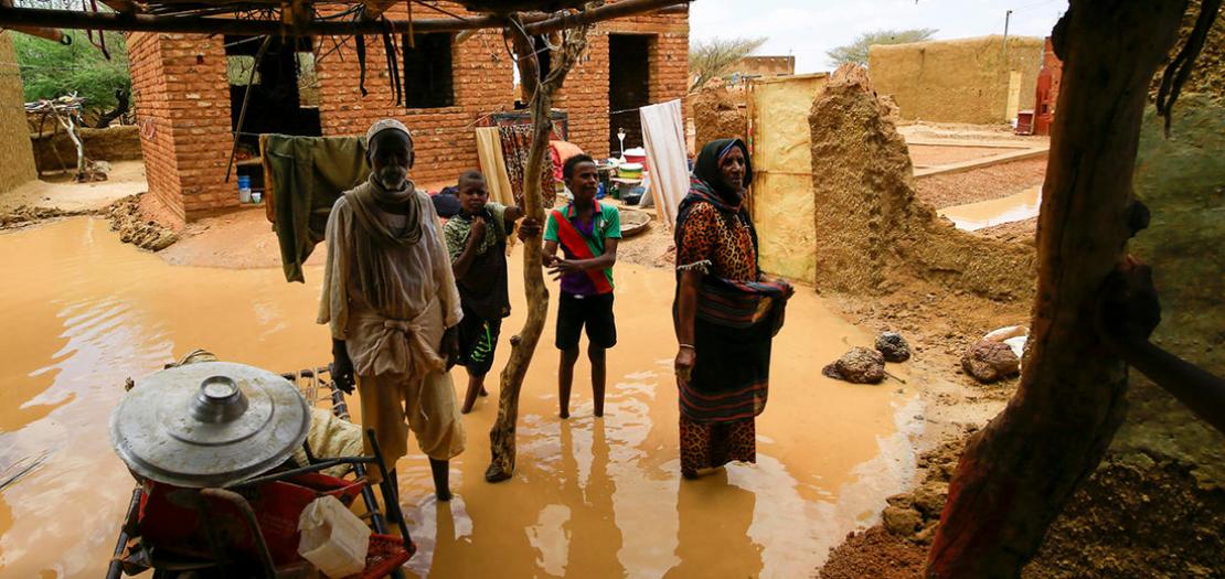 عائلة سودانية تعاين الأضرار في منزلها جنوب شرق العاصمة الخرطوم في 2 آب 2020 عقب أمطار غزيرة سببت انزلاقات أرضية وفيضانات