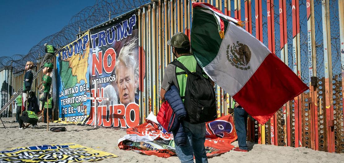 متظاهر يحمل علم المكسيك اثناء احتجاج ضد الرئيس الأميركي دونالد ترامب في ولاية باها كاليفورنيا على الحدود مع الولايات المتحدة، في 31 تشرين الأول 2020