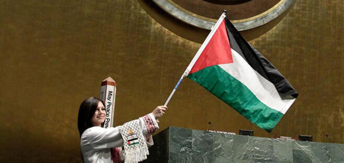 شابة فلسطينية ترفع علم فلسطين خلال مناسبة خاصة في قاعة الجمعية العامة للأمم المتحدة