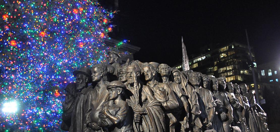 مجسم "الملائكة المجهولون" (نسخة طبق الأصل عن العمل الفني الموجود في ساحة القديس بطرس بالفاتيكان) أمام شجرة عيد الميلاد التي أقامتها أبرشية بروكلين في ساحة الجيش الكبرى بنيويورك، 8 كانون الأول 2020