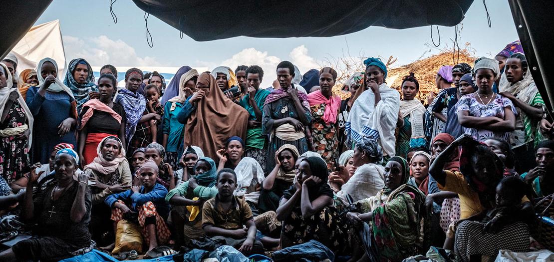 نازحون فارون من العنف الاتني في منطقة ميتيكيل في غرب إثيوبيا حول خيمة حيث تم توزيع الملابس في مخيم تشاغني، 27 كانون الثاني 2021