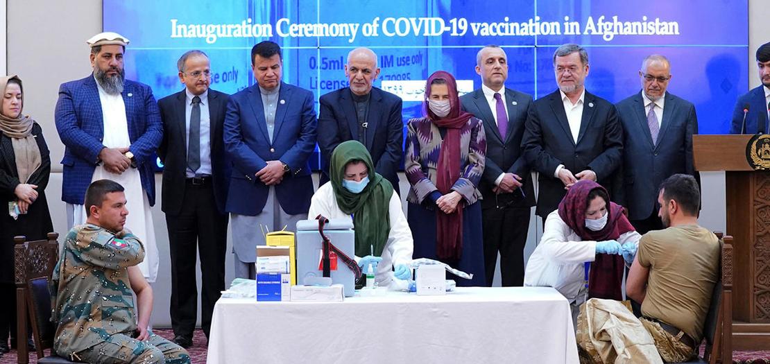 عنصر من القوات الأمنية في افغانستان يتلقى جرعة من اللقاح ضد كوفيد-19 خلال حفل اطلاق حملة التلقيح في القصر الرئاسي في 23 شباط 2021.