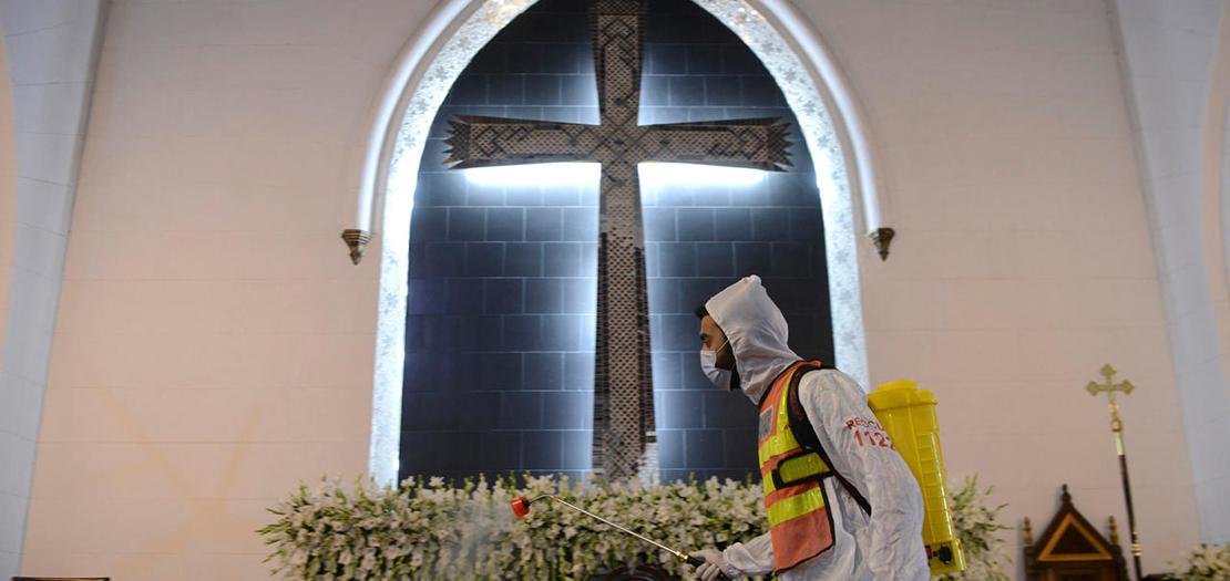 عامل يتولى تعقيم كاتدرائية القديس يوحنا في بياشور، 3 نيسان 2021