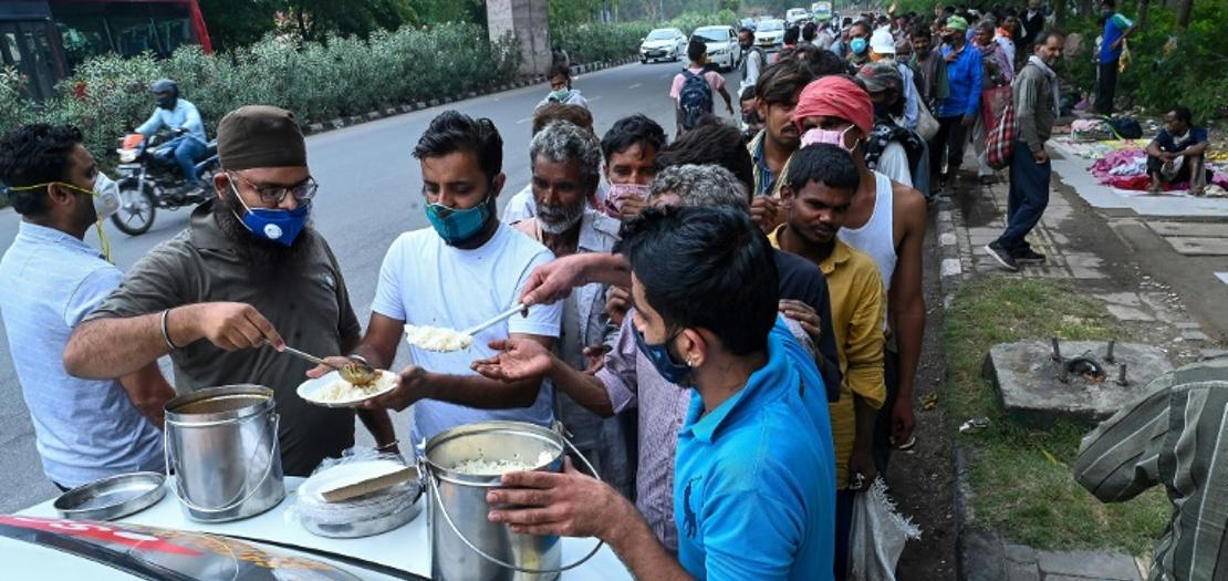 مشرّدون يصطفون للحصول على الطعام على جانب طريق في نيودلهي، 20 أيار 2021