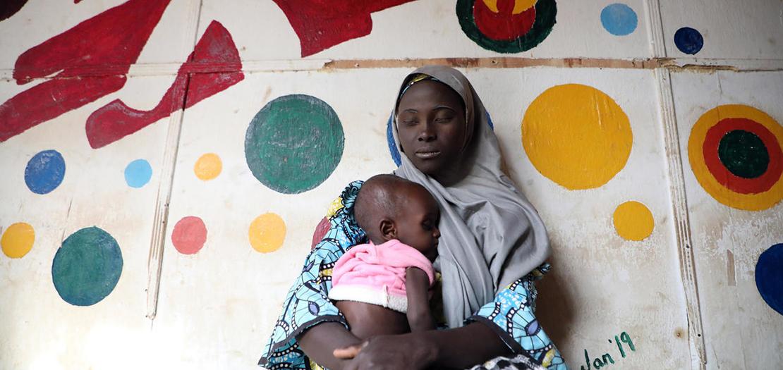 صورة من الأرشيف التُقطت في 4 كانون الأول 2019 تظهر فيها امرأة مريضة جاسلة مع طفلها في مستشفى أنكا حيث تقدم منظمة "أطباء بلا حدود" الرعاية الصحية للأطفال والنساء في أنكا قرب غوسو في نيجيريا
