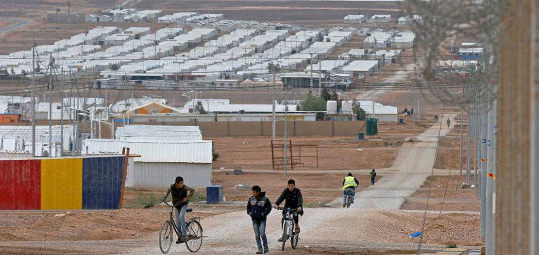 أطفال لاجئون سوريون يركبون دراجاتهم في مخيم الأزرق للاجئين في الأردن