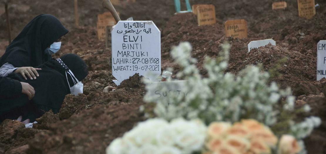 امرأة تبكي قرب قبر أحد ضحايا كوفيد في مقبرة في بيكاسي بإندونيسيا، في 20 تموز 2021