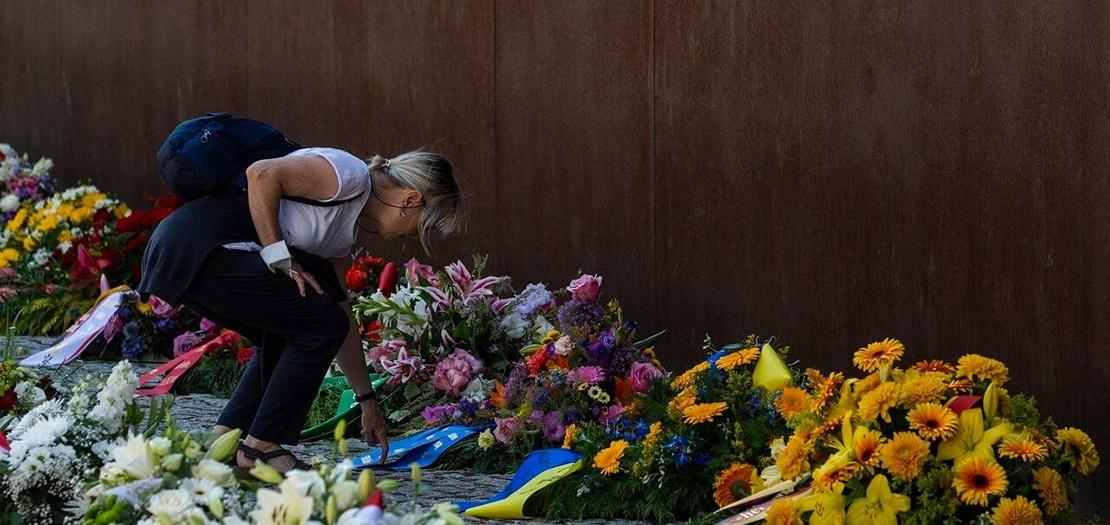 امرأة تضع إكليلا من الزهور خلال إحياء الذكرى الستين لبناء جدار برلين، 13 آب 2021