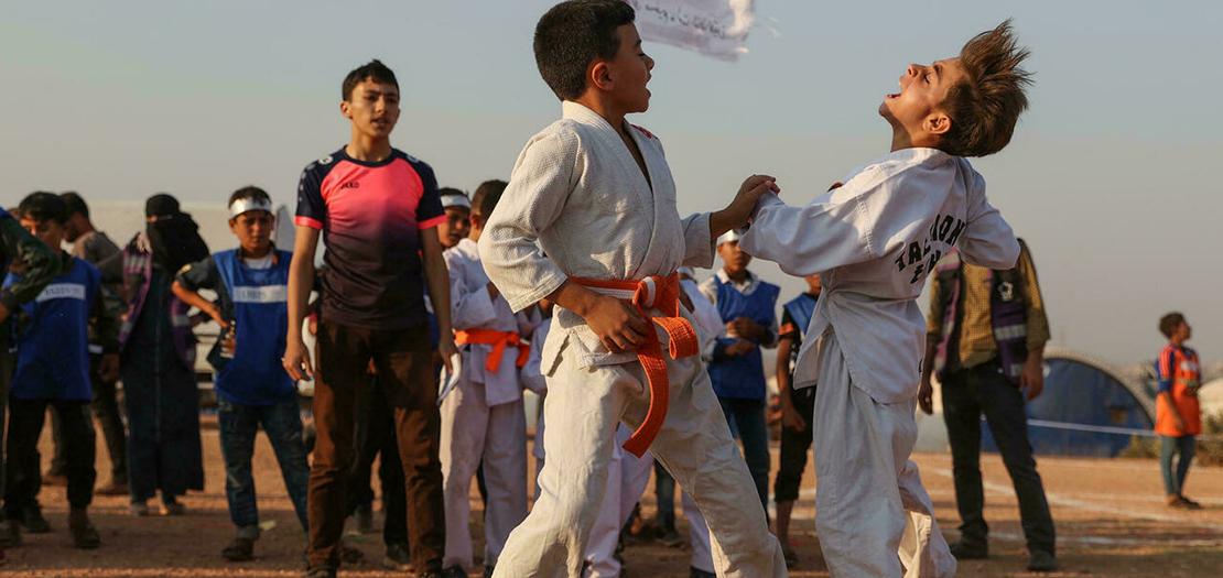 طفلان يتبارزان في الكاراتيه خلال فعاليات "أولمبياد الخيام" في إدلب شمال غرب سوريا، 7 آب 2021
