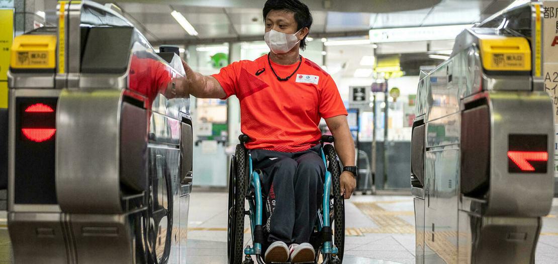 صورة لرياضي الكانوي لذوي الاحتياجات الخاصة الياباني ماساكي سوا عند أحد مداخل محطة القطارات في طوكيو، 23 آب 2021
