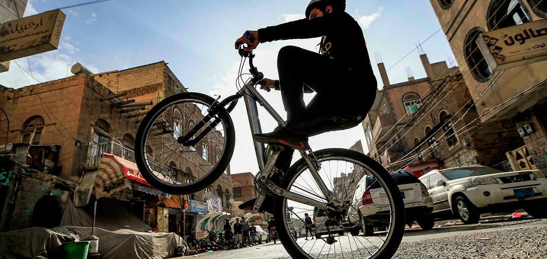 فتى يقوم بحركة بهلوانية على دراجته خلال مشاركته مع عشرات الدراجين في رحلة انطلاقا من صنعاء حتى صعدة في الشمال، في 25 آب 2021