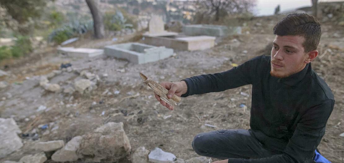 شاب فلسطيني يعرض عظام أحد الأموات في المقبرة اليوسفية شرق البلدة القديمة في القدس الشرقية المحتلة