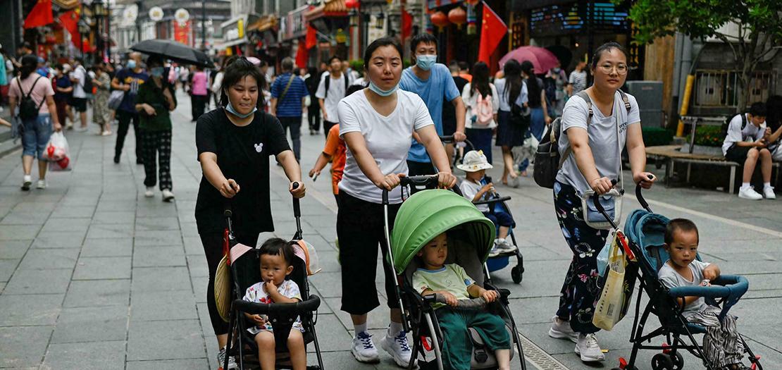 ثلاث نساء يسرن مع عربات أطفال في بكين في 13 تموز 2021