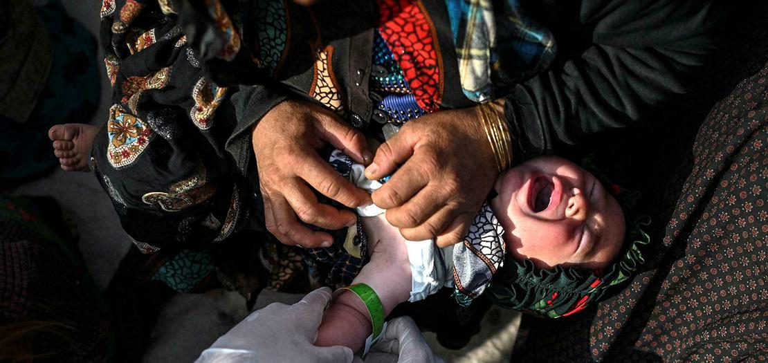 موظفة من منظمة "أطباء بلا حدود" تتحقق من مؤشرات سوء التغذية لدى طفل في مخيم نازحين في ضاحية هرات في 22 تشرين الثاني 2021