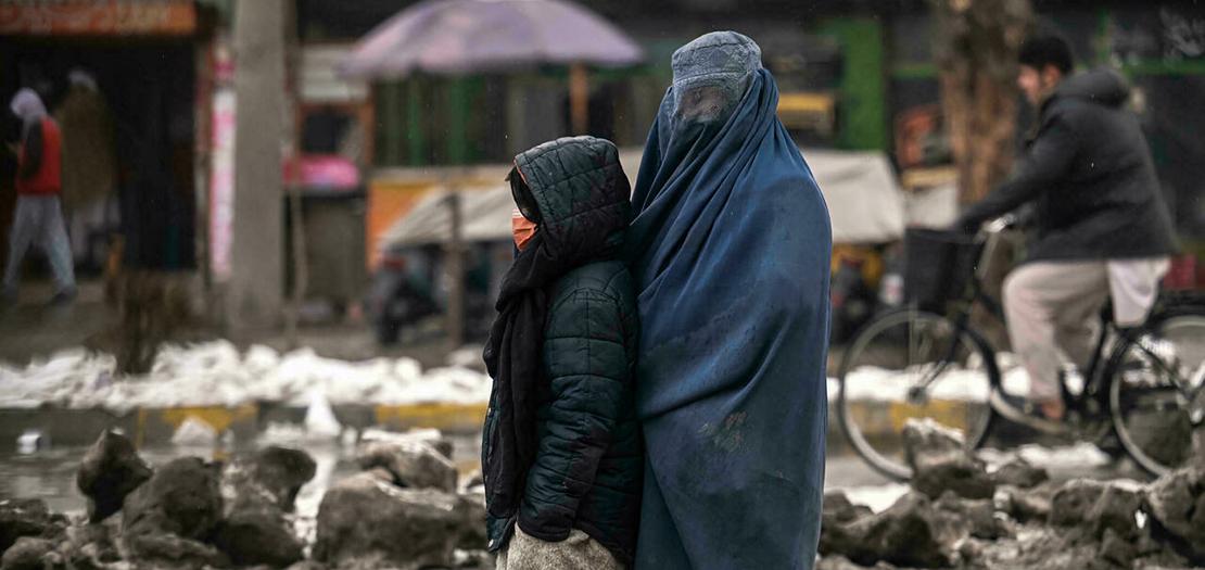 أفغانية تتسول مع طفلة في أحد شوارع كابول في 8 كانون الثاني 2022