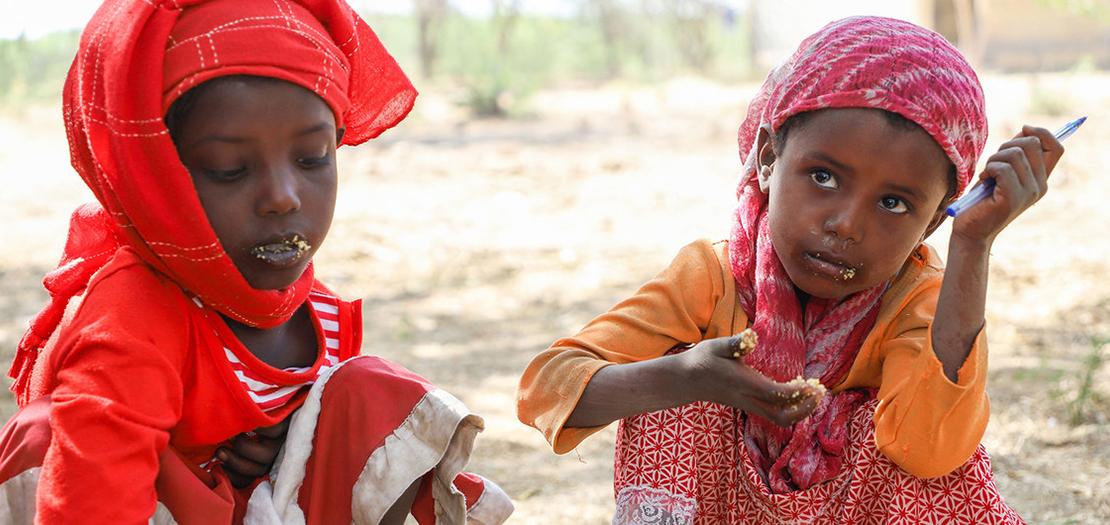 فتاتان صغيرتان تنتظران الطعام الذي يوزعه برنامج الأغذية العالمي في إثيوبيا