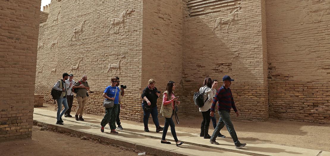 سياح أجانب يزورون موقع بوابة عشتار التي أعيد استنساخها عن البوابة الأصلية في بابل بوسط العراق، 7 آذار 2022