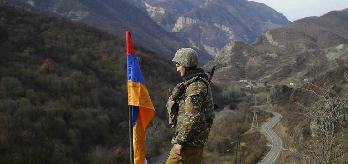 صورة من الأرشيف لجندي أرميني إلى جانب علم بلاده في إقليم ناغورني قره باغ. 