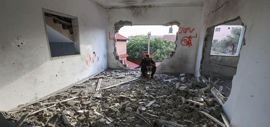 فلسطيني جالس في منزل بعدما دمرته القوات الإسرائيلية في بلدة السيلة الحارثية قرب جنين، 7 أيار 2022
