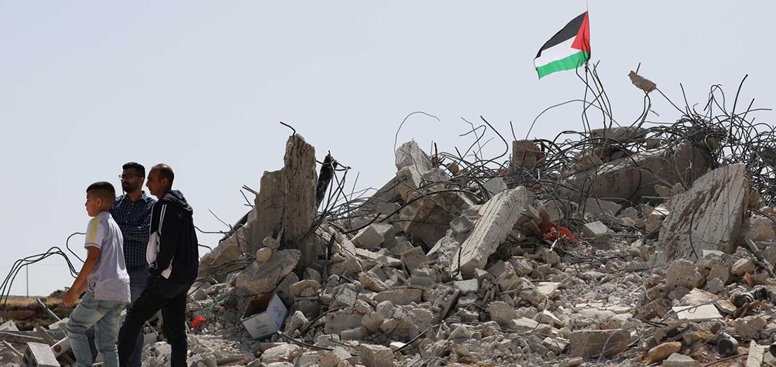 فلسطينيون يتفقدون منازلهم التي هدمها الاحتلال في قرية بيت دجن في نابلس، 9 أيار 2022