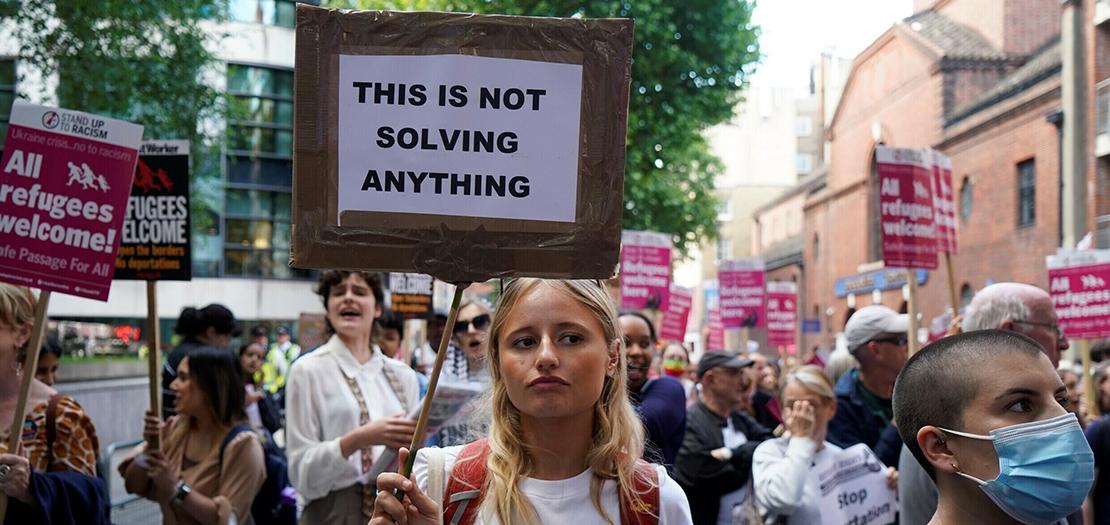 متظاهرة ضد عمليات ترحيل مهاجرين من بريطانيا الى رواندا امام وزارة الداخلية في لندن، 13 حزيران 2022.