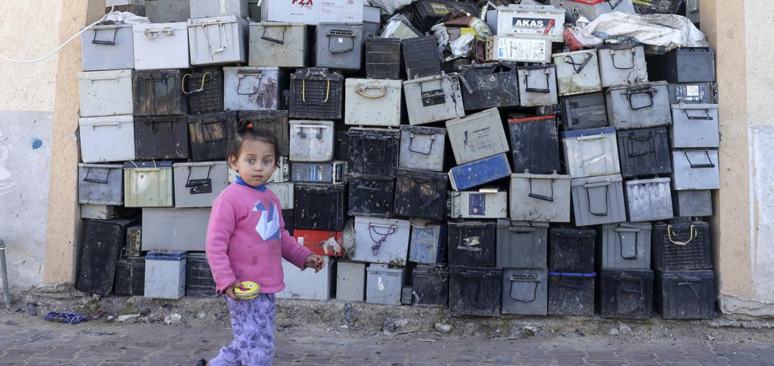 فتاة تمرّ قرب مكب بطاريات للتدوير في جنوب قطاع غزة، 14 شباط 2022