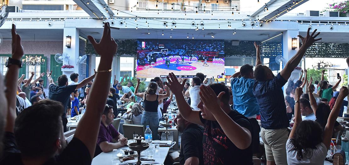لبنانيون يشجعون منتخب بلادهم خلال نهائي كأس آسيا لكرة السلة أمام أستراليا، في أحد مقاهي العاصمة بيروت، 24 تموز 2022
