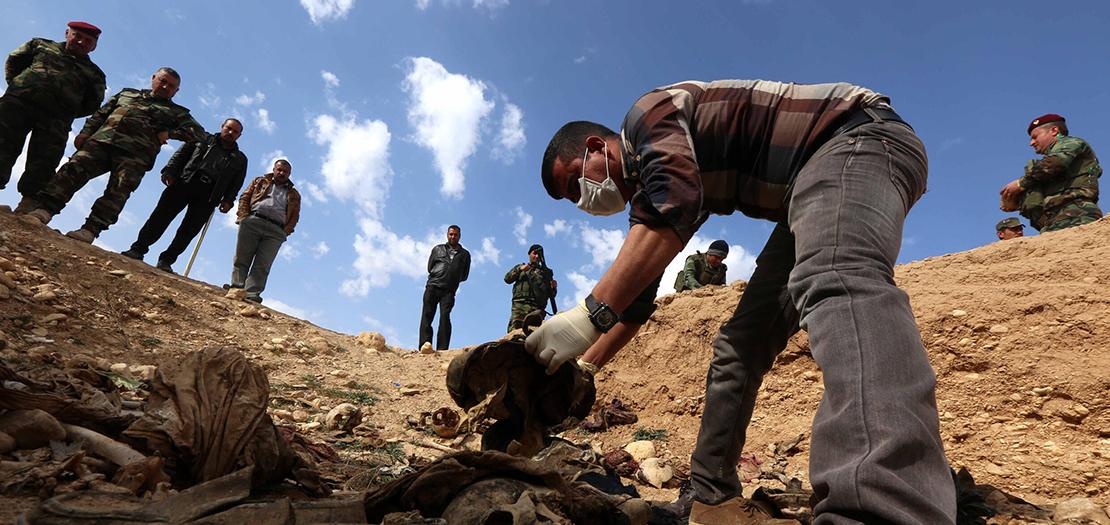 افراد من الاقلية الايزيدية في العراق يبحثون عن ادلة تتيح العثور على رفات اقربائهم الذين فقدوا او قتلوا على ايدي داعش في مقبرة بمنطقة سنجار، 3 شباط 2015