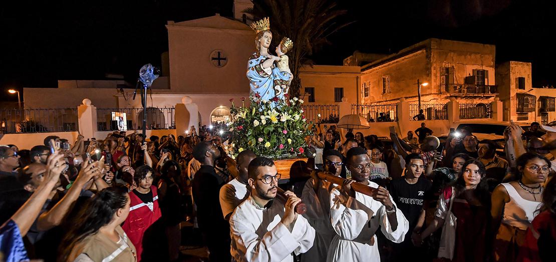 مؤمنون يحملون تمثال سيّدة تراباني خلال الدورة السنوية انطلاقًا من كنيسة القديس أوغسطينوس والقديس فيديل في ضاحية حلق الوادي في العاصمة تونس، 15 آب 2022