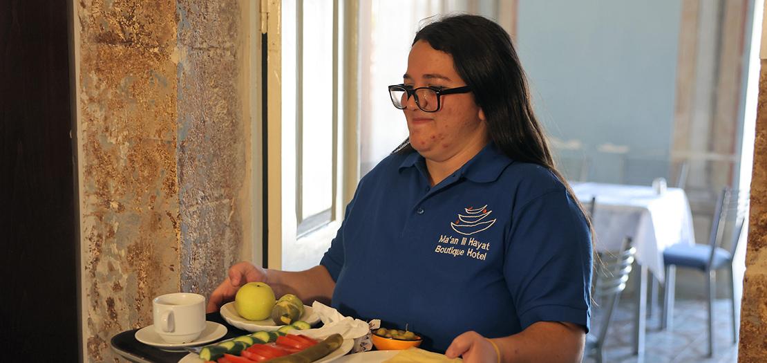 مريم كنسان (27 عامًا)، وهي من ذوي الإعاقات، تعمل في فندق تديره جمعية "معًا للحياة"