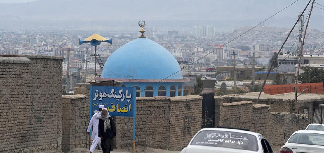 رجال أفغان يمشون قرب مسجد في 18 آب 2022 في ضواحي كابول