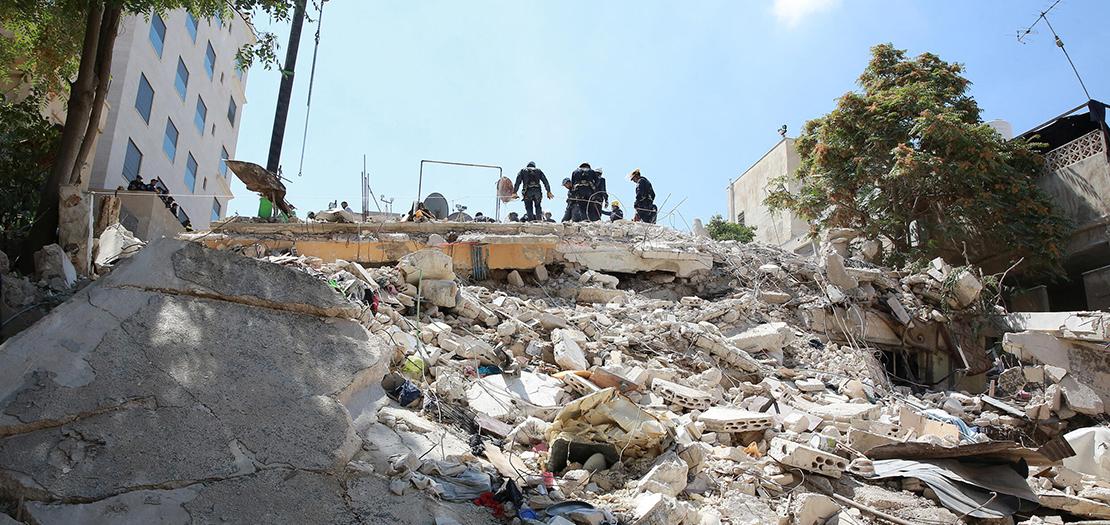 عمال إنقاذ بين انقاض مبنى منهار في عمان في 14 أيلول 2022