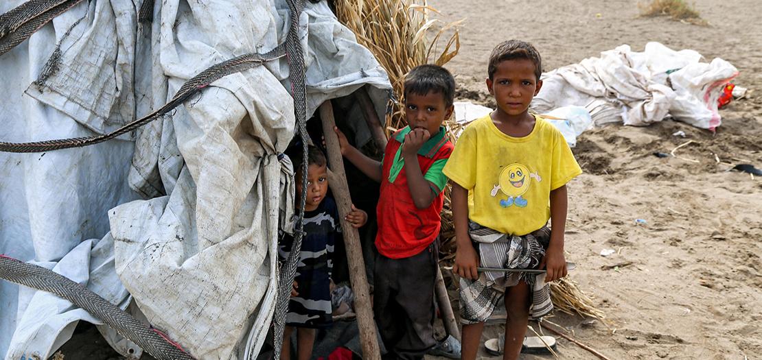 أطفال يقفون خارج خيمة في مخيم للنازحين تضرر من السيول في منطقة الجراحي التي دمرتها الحرب بمحافظة الحديدة غرب اليمن، 19 أب 2022.