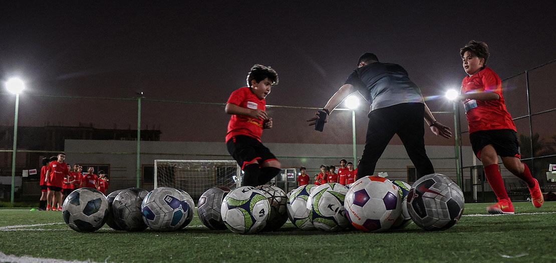 أطفال يلعبون كرة القدم في أكاديمية "سيدرز" الرياضية في العاصمة القطرية الدوحة
