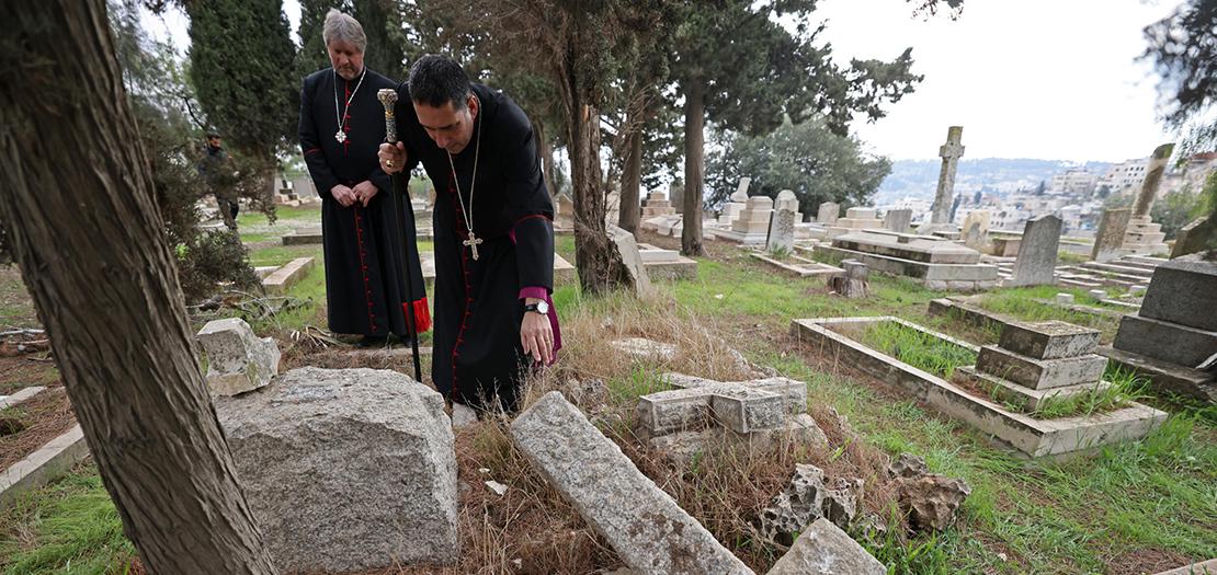 المطران حسام نعوم، رئيس الأساقفة الأنغليكاني، يتفقد القبور المخربة في جبل صهيون خارج البلدة القديمة في القدس في 4 كانون الثاني 2023