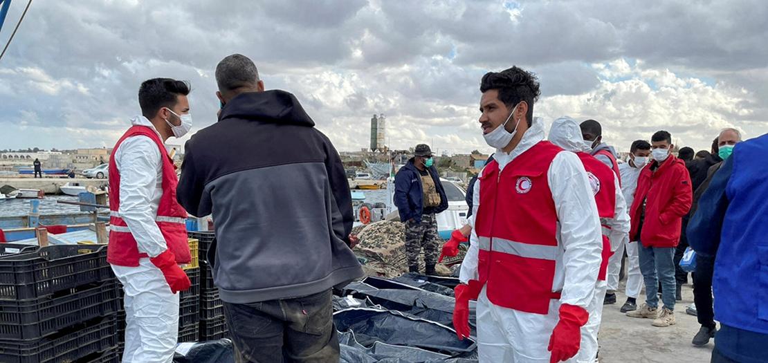 عاملون في الهلال الأحمر الليبي أمام جثث مهاجرين توفوا بعد غرق قاربهم في مدينة القره بولي، ليبيا، 25 كانون الثاني 2023