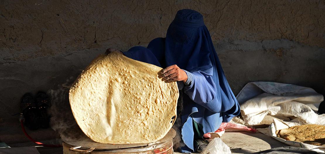 امرأة أفغانية تعدّ خبزا لبيعه في سوق في قندهار في الخامس من كانون الثاني 2023