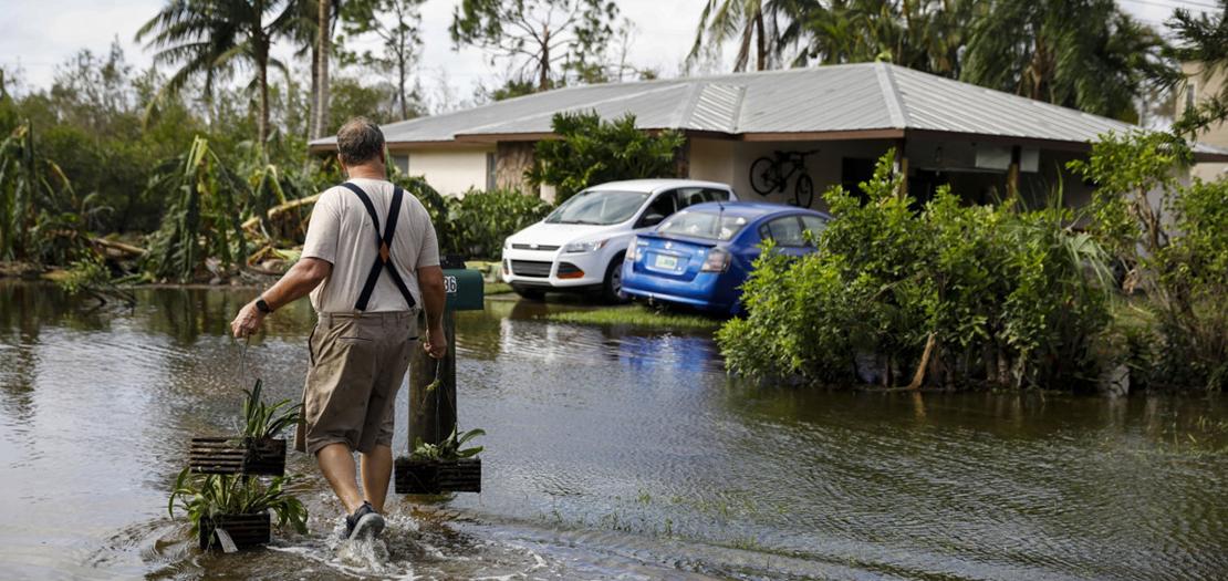 رجل يتوجه إلى منزله سيرًا على أقدامه عقب إعصار إيان في سبتمبر في فورت مايرز، فلوريدا