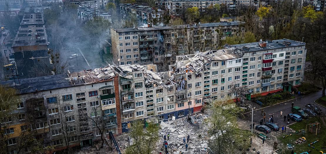 عناصر انقاذ في مبنى سكني مدمر جزئيًا بعد قصف على سلوفيانسك بشرق أوكرانيا، 14 نيسان 2023