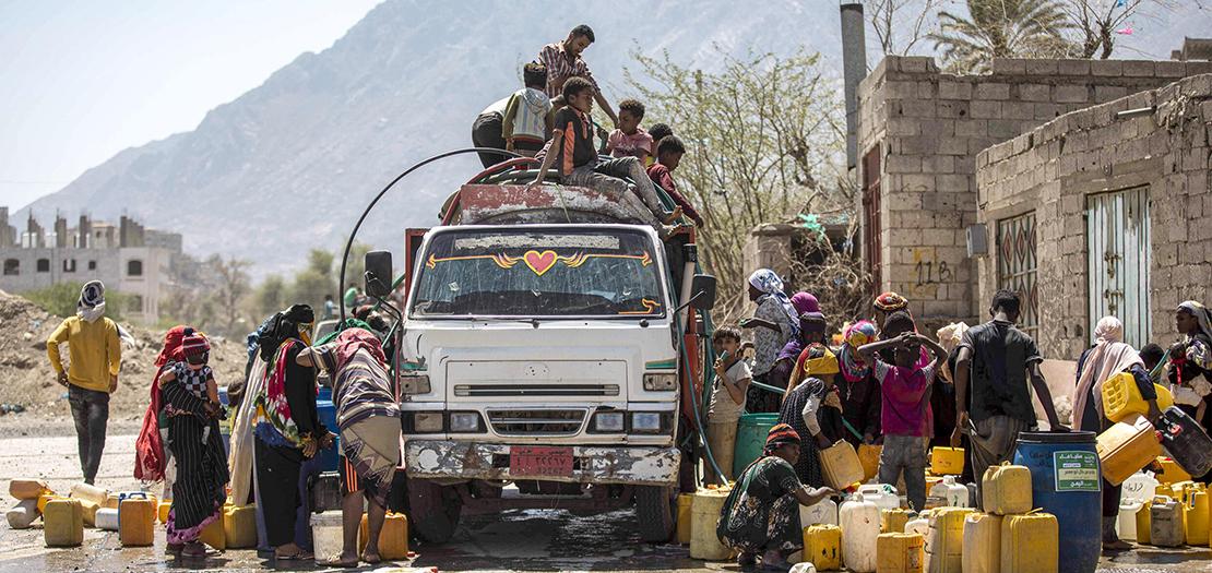 أشخاص يتجمّعون قرب صهريج مياه لملء حاوياتهم على مشارف مدينة تعز في جنوب غرب اليمن، 8 حزيران 2023