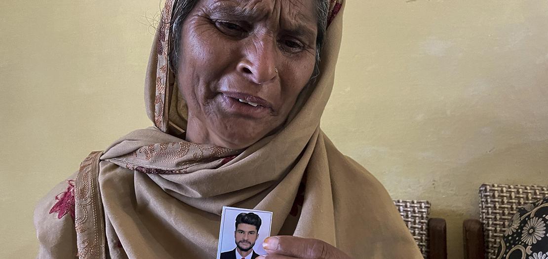 والدة أحد الأشخاص الذي فقدوا في غرق قارب المهاجرين في اليونان تحمل صورة له وتبكيه في قرية باندلي بالشطر الذي تسيطر عليه باكستان من كشمير، 20 حزيران 2023