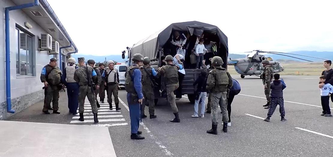 مدنيون يخرجون من شاحنة أثناء عملية إجلاء لقوات حفظ السلام الروسية